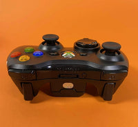 Bežični Xbox 360 kontroler povezan sa konzolom u pozadini